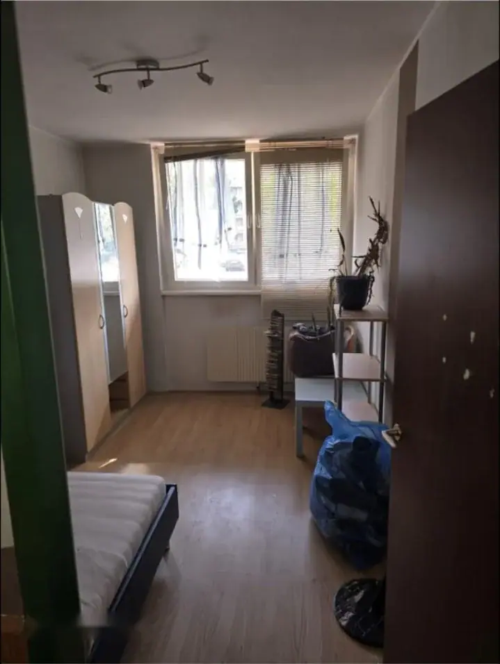 Zimmer mit Kästen, Matratze und gefüllten Müllsäcken